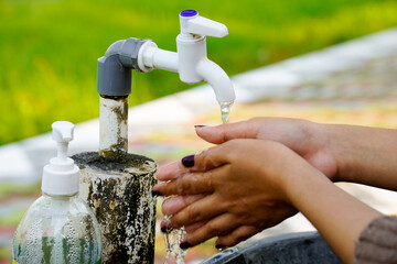 view of a woman's hands washing under a running water tap.