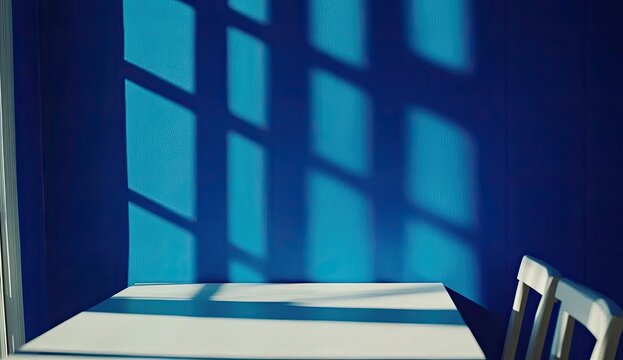 Sunlight casts shadows on a blue wall through a window