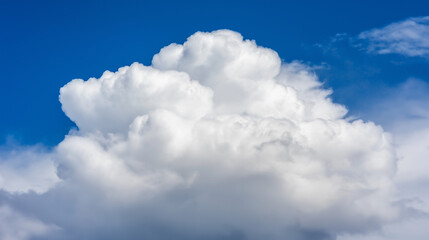 Obraz premium White fluffy cloud in a summer sky, embodying serenity and dreamy beauty