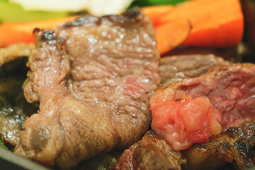 Beef and vegetables are being grilled on a hot plate, the beef looks delicious and tasty!