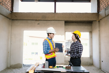 Architects and engineers collaborate at a desk with blueprints and solar panels, planning...