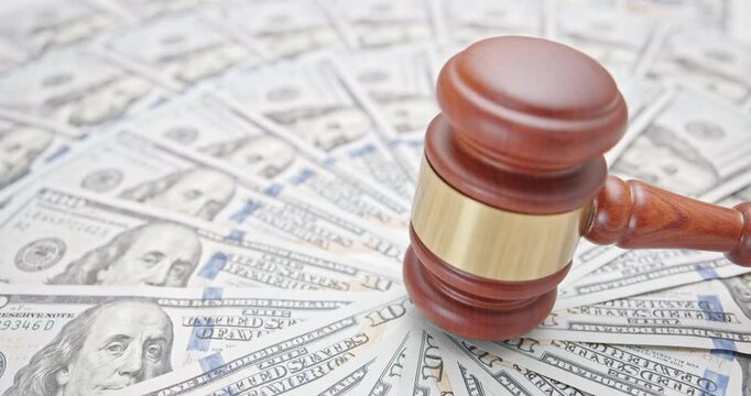 Financial sanctions, trade war, reciprocal tariffs, and economic power struggle : A gavel symbolizing justice and legal authority placed on a backdrop of U.S. dollars, U.S.-China trade conflict.