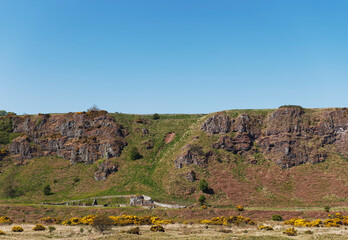 The view across the grasslands behind St Cyrus Beach to the Nether Kirkyard Burial ground at the foot of the Volcanic Cliffs with a distinct Fault line.
