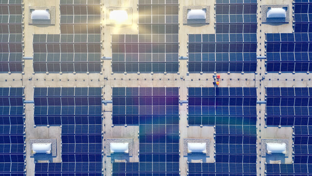 A bird's-eye view of a vast solar farm, illustrating the scale and potential of renewable energy, emphasizing eco-friendly green technology.