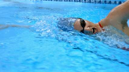 Athlete glides through the pool, demonstrating speed and skill in an intense swim training session.