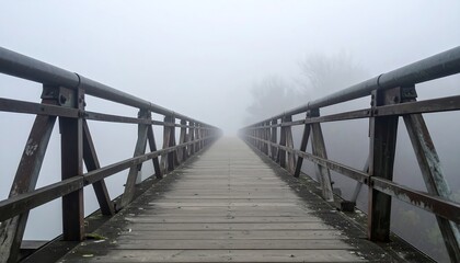 Obraz premium Wooden Bridge Vanishing into Dense Fog