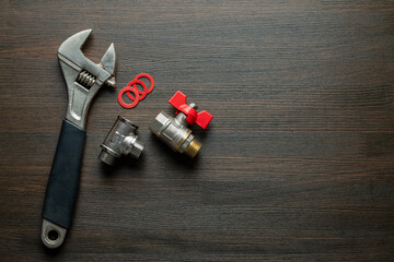 Metal adjustable wrench, ball valve with red handle, stainless steel tee fittings and rubber...