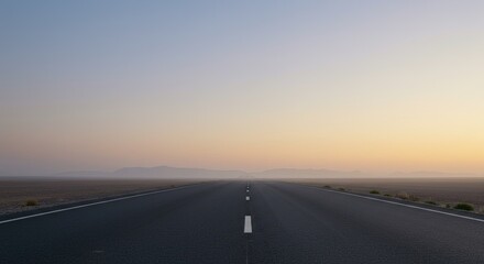 Fototapeta premium Empty road stretching into a hazy sunrise over a desert landscape
