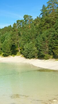Bright turquoise lake Urisee nestled in the Austrian Alps with forested surroundings and relaxing natural silence in Reutte Tirol