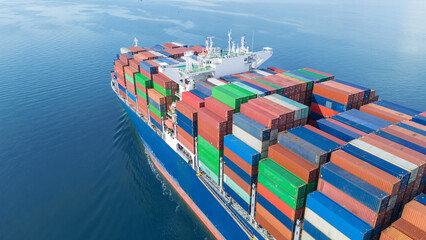 Fototapeta premium Aerial side view of a large cargo ship fully loaded with colorful shipping containers navigating through calm ocean water. Ideal for logistics, transport, and global trade concepts.