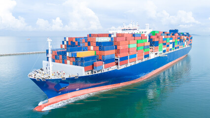 Aerial front view of a large cargo ship fully loaded with colorful shipping containers navigating through calm ocean water. Ideal for logistics, transport, and global trade concepts.