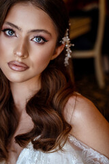 close-up, portrait of a young brunette bride in a white dress with a corset.