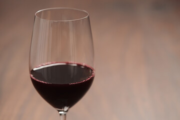 Red wine in thin wine glass on wood table
