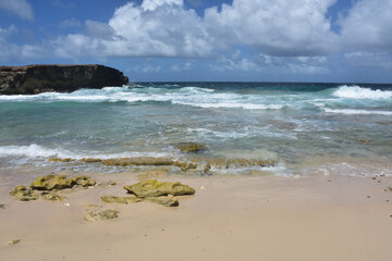 Waves Rolling Ashore Under Puffy White Clouds