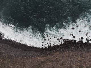 Aerial View of Waves Breaking on Rocky Shoreline