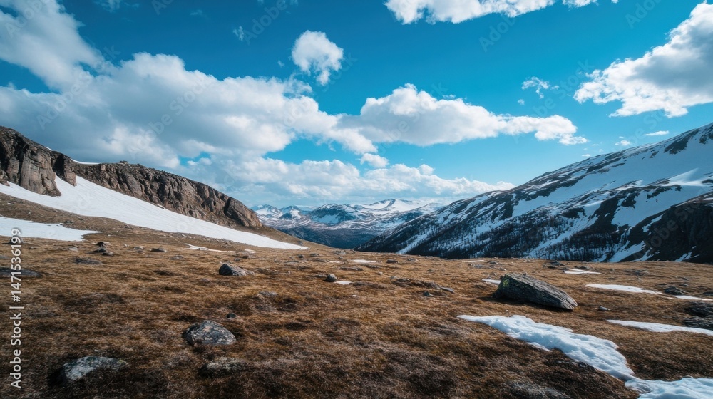 Poster a breathtaking panoramic view of a snow-capped mountain range under a vibrant blue sky, with patches