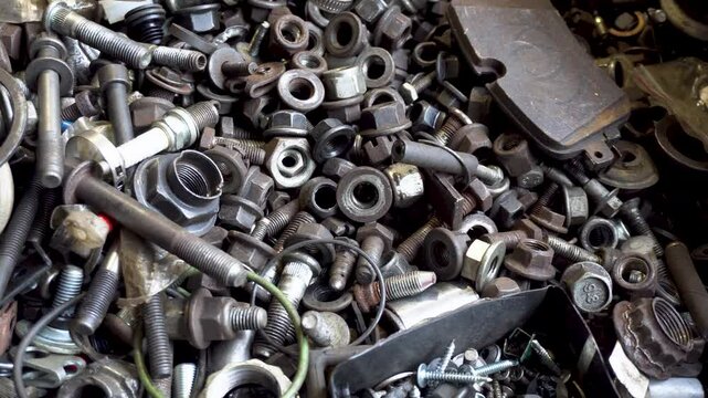 Car service. Mechanic sorting through a bunch of nuts and bolts. Car repair concept. Car maintenance