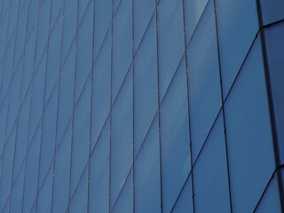 Sleek Modern Architectural Detail of Glass Skyscraper Against Clear Sky with Diagonal Lines