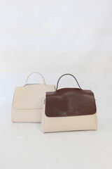 Black, white and brown handbags on light background