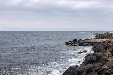 Rocky Bulgarian seaside with waves under cloudy sky