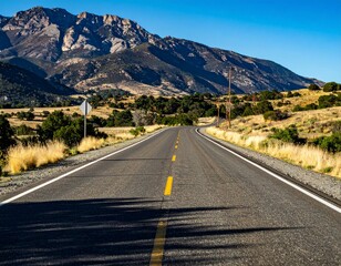 Naklejka premium Scenic Open Road through Mountain Landscape under Clear Blue Sky