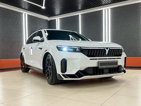 White Voyah Free elegant E-SUV in showroom. Front view, side. Car manufacturer from China. Exterior Chinese E-SUV. Dongfeng Motor. Exterior of the Voyah Free. 