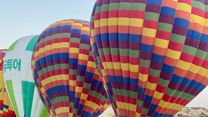 Obraz premium Multiple vibrant hot air balloons are ready for takeoff, showcasing an array of colors against the early morning sky in Goreme. This enchanting scene captures the beauty of Cappadocia's landscape