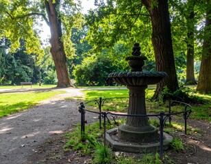 Serene Park Fountain Surrounded by Lush Green Trees and Pathways