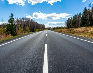 Fototapeta premium Scenic Empty Road Under Bright Sky with Fluffy Clouds and Trees