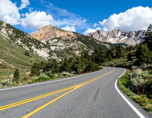 Naklejka premium Serene Winding Mountain Road Under Blue Sky and White Clouds