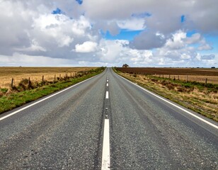 Open Road with Sparse Landscape Under Dramatic Sky and Clouds
