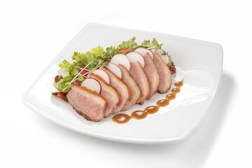 Gourmet duck breast slices with radish and salad on white plate