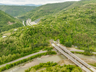 Aerial view of a quiet highway passing through a tunnels in a picturesque hilly region Rikoti Pass