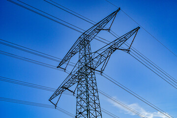 Power poles in spring on the field and meadow, Brandenburg, Germany