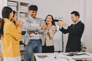 Group of Young Asian business team creative businesspeople coworker in office Happy to be successful partnership teamwork celebrating achievement and success concept.