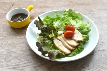 grilled  slice chicken breast with vegetable salad on plate dressing Japanese sesame oil soy sauce