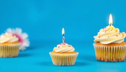 Single vanilla cupcake with lit candle on vibrant blue background, celebratory, baking