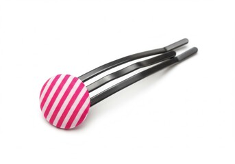 Close-up of a black bobby pin with a pink and white striped fabric button on a white background