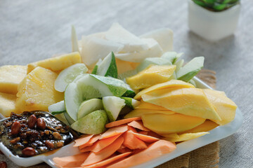 Mango sliced and pickled cucumber on wood table background