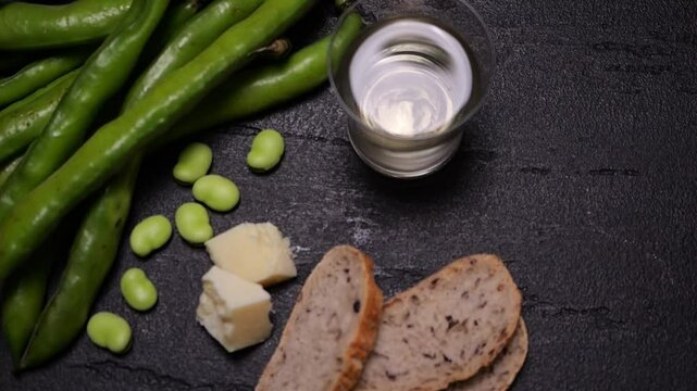 Fave, pecorino e pane con bicchiere di vino 