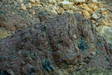 Close-up of rocky surface in Sharjah desert mountains. Distinct mineral layers and color variations reveal ancient geological formations.