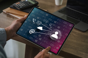 Businessman typing on laptop with contact us icons overlay. Concept of customer support, communication, and digital contact service for business or corporate websites.