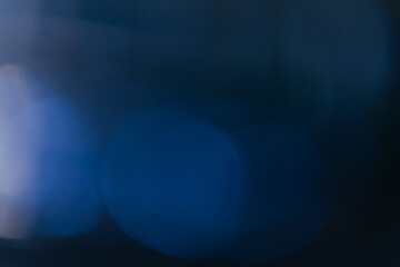 Blue background created in camera with a macro lens with overlapping bokeh circular shapes soft edges light and dark areas with room for copy and text.