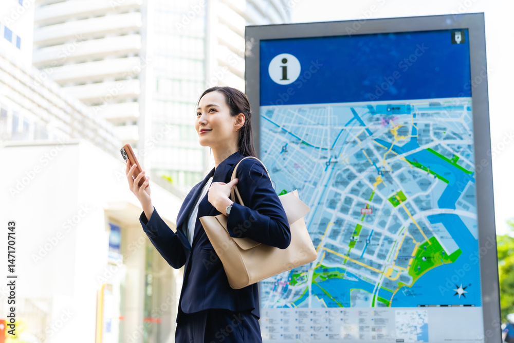 Poster 地図とスマホを見て場所を確認する女性ビジネスパーソン