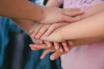 Team Huddle A friendly family joins their hands as a sign of joint success Stack of hands, below and children in nature for unity, support and friendship, girls stacking hands together in teamwork