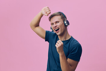 Enthusiastic young man wearing headphones, smiling and celebrating with fist pump, exhibiting joy...