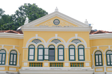 A vibrant yellow color British colonial era grand mansion near Merdeka Square in Kuala Lumpur, Malaysia. This heritage building shows Chinese and western influenced architecture in Southeast Asia.
