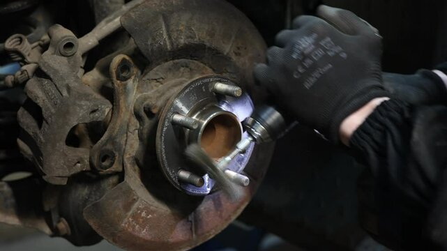 Mechanic Installing Wheel Spacer on Car Hub Close-up video of a mechanic using a wrench to install a wheel spacer