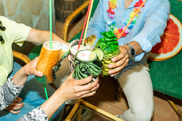 Friends celebrating with tiki cocktails in a hawaiian bar