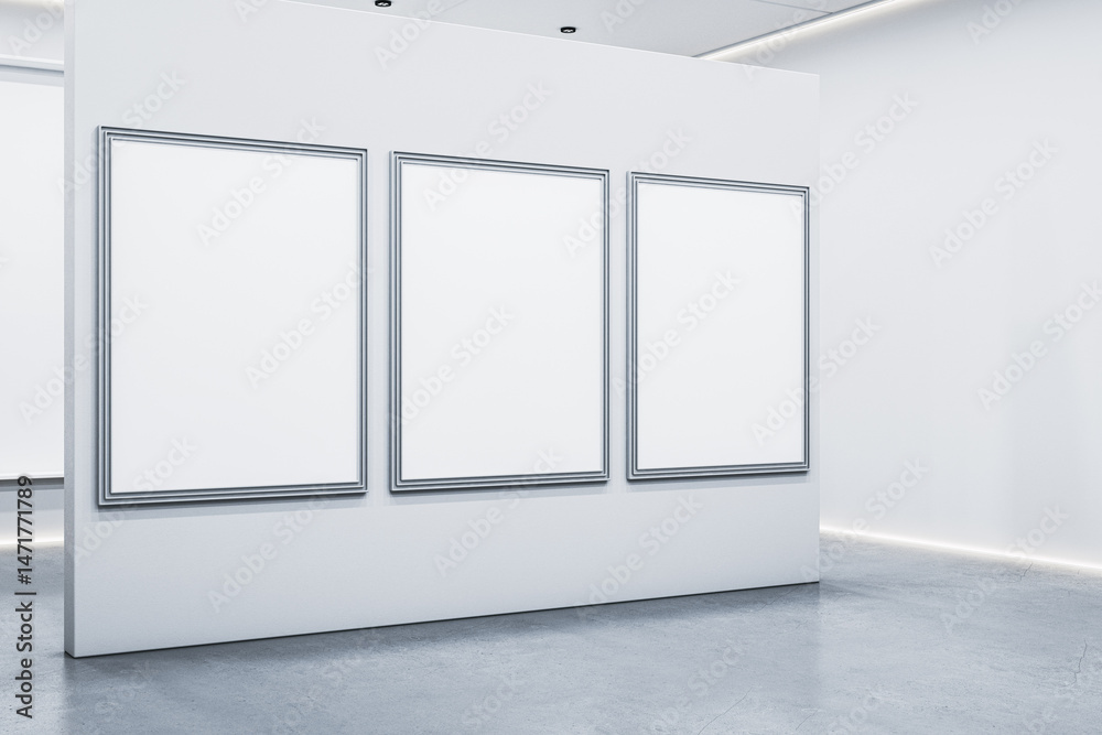 Poster blank silver-framed posters on white gallery wall in minimal modern interior with concrete floor and
